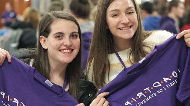 Students holding up 公路旅行 t-shirts